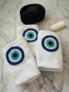 White towels with blue and black eye designs on a white surface