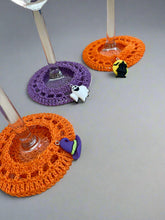 Load image into Gallery viewer, Crocheted glass coasters in orange and purple on a concrete surface especial Halloween
