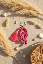 Load image into Gallery viewer, Pink crocheted keychain with tassel on a gray background
