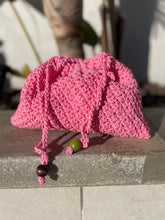 Load image into Gallery viewer, Pink knitted hat with a green bead on a concrete surface
