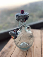 Load image into Gallery viewer, Small glass bottle with a knitted cap on a wooden surface
