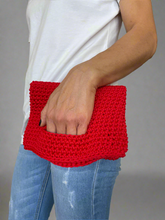 Load image into Gallery viewer, Person holding a red knitted clutch bag against a gray background
