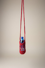 Load image into Gallery viewer, Red crocheted bottle holder with a blue bottle on a white background
