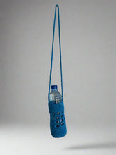 Load image into Gallery viewer, Blue crocheted water bottle holder with a bottle on a gray background

