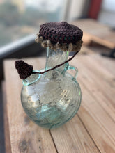 Load image into Gallery viewer, Small glass bottle with a textured cap on a wooden surface
