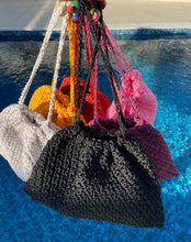 Load image into Gallery viewer, Colorful crocheted bags hanging by a pool
