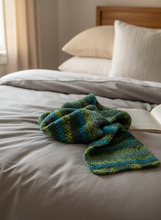 Load image into Gallery viewer, Green blue crochet winter scarf naturally draped on bed

