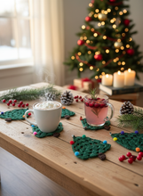 Load image into Gallery viewer, Handmade crochet Christmas tree coasters with pompoms in festive holiday home setting
