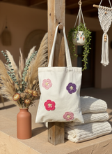 Load image into Gallery viewer, Lifestyle scene with crochet flower tote bag

