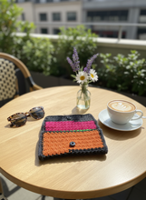 Load image into Gallery viewer, Multicolored crochet clutch in stylish daytime setting
