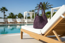 Load image into Gallery viewer, Purple crochet bag on a sunbed 
