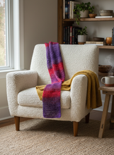 Load image into Gallery viewer, Red purple crochet winter scarf on armchair
