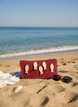 Load image into Gallery viewer, Red raffia clutch on beach
