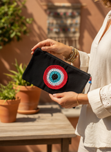 Load image into Gallery viewer, Woman holding black canvas pouch with red evil eye charm
